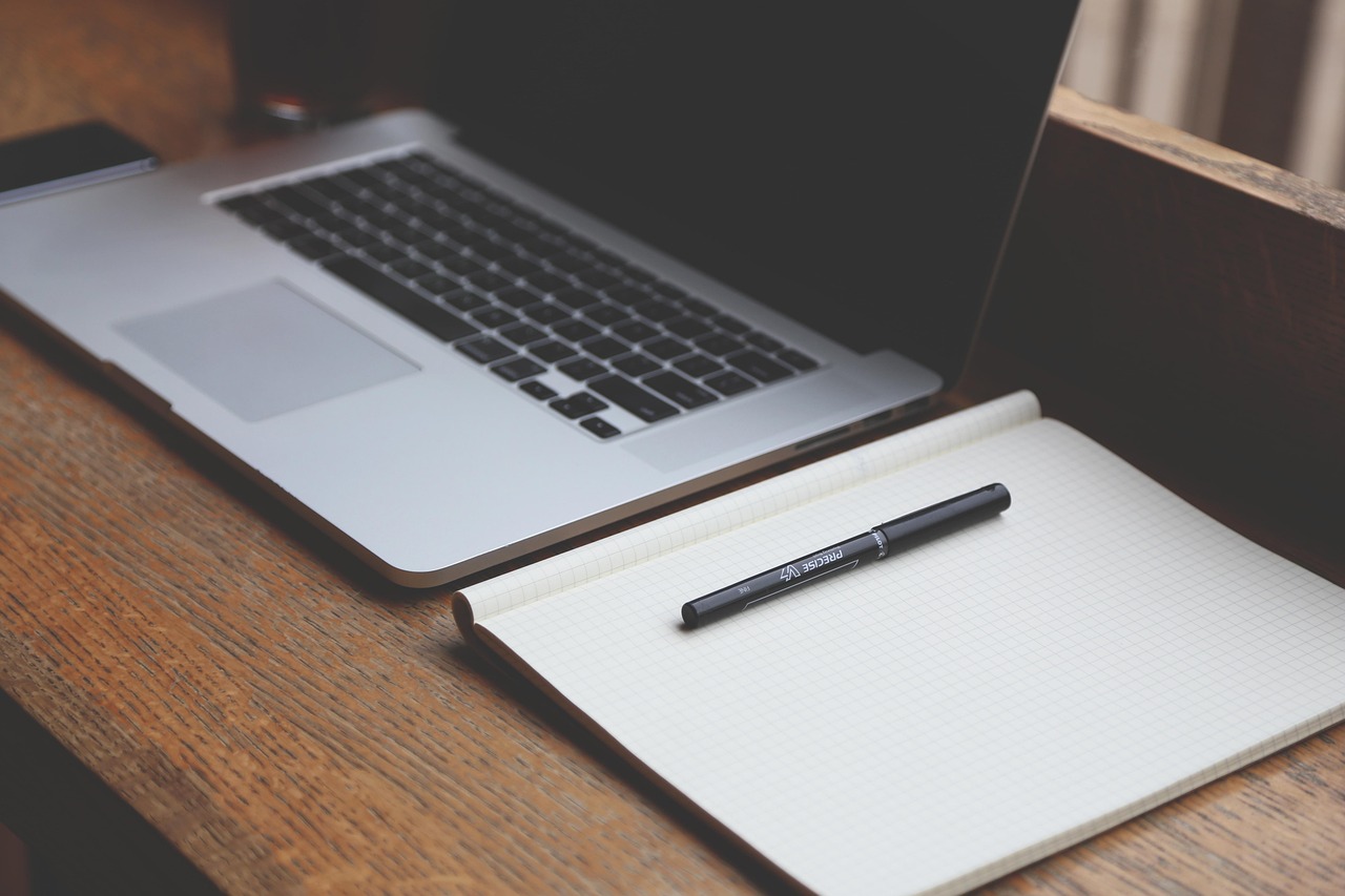 Person working on laptop from home office doing virtual bookkeeping
