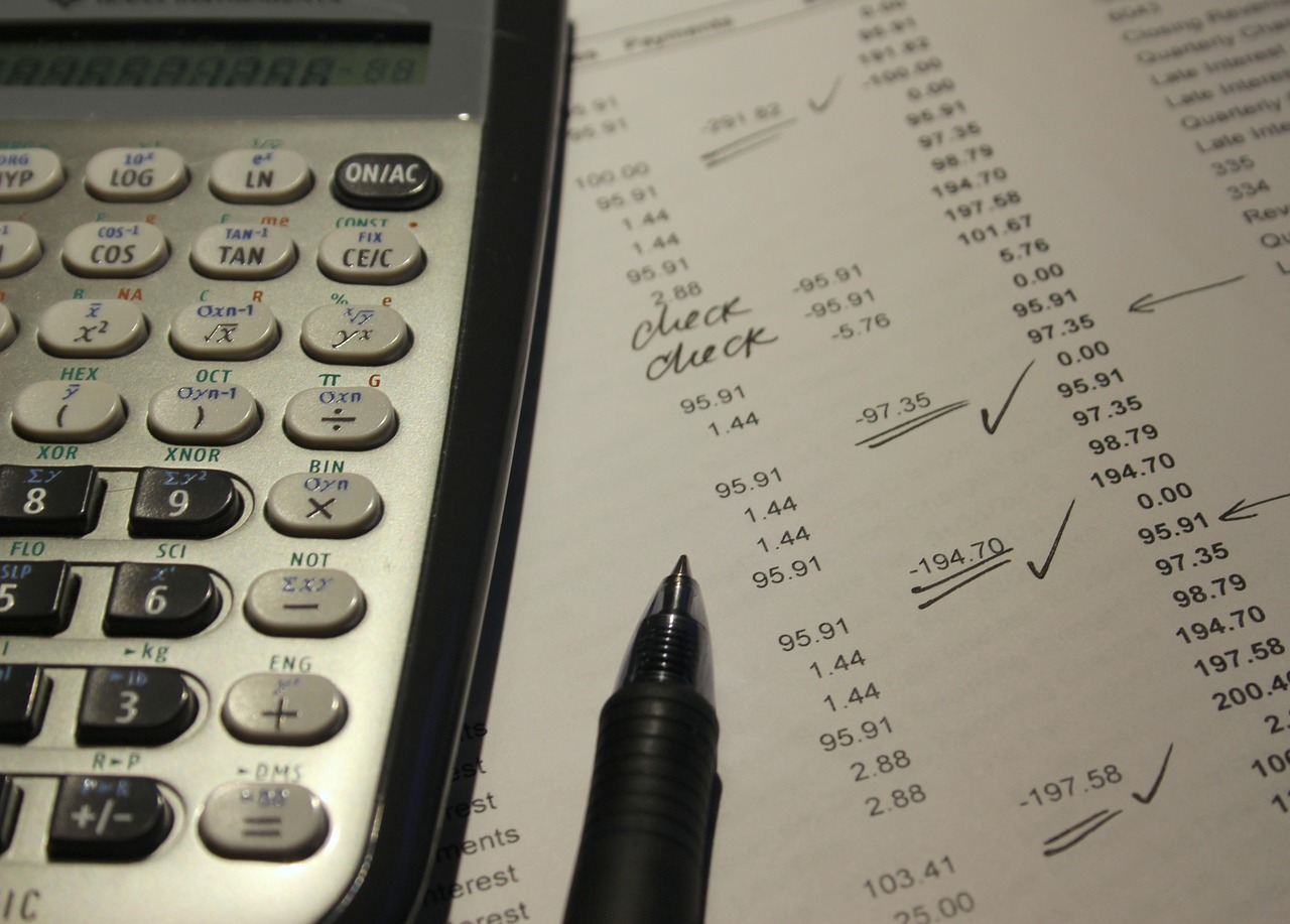 Small business owner reviewing financial reports with calculator